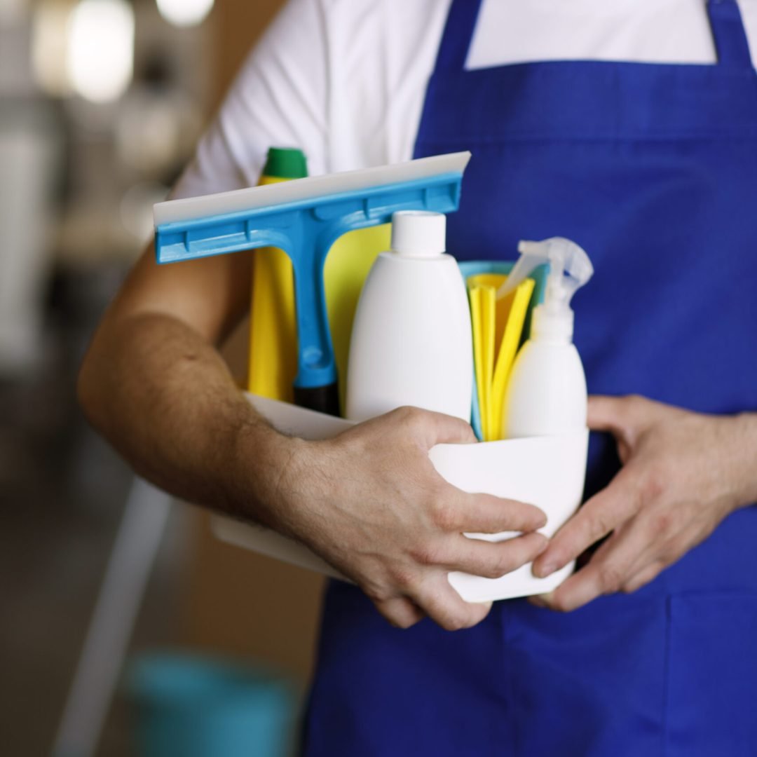 vista-da-pessoa-servico-de-limpeza-profissional-segurando-suprimentos